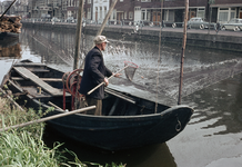 849500 Afbeelding van een visser met zijn vissersboot in de Leidsche Rijn te Utrecht, ter hoogte van houthandel De Wit. ...